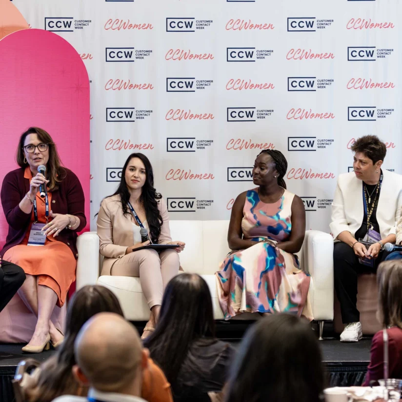 Six women sit on a panel stage, engaging in discussion at a conference with a CCWomen backdrop and audience members visible in the foreground.