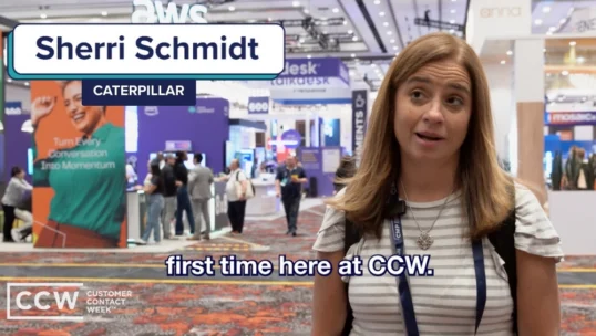 A woman stands in a convention center, wearing a striped shirt and conference badge. Text reads: "Sherri Schmidt, Caterpillar. First time here at CCW." People and booths are visible in the background.