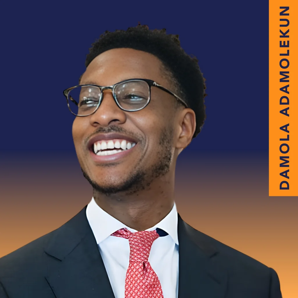 A man in a suit and red tie smiles, wearing glasses, against a blue and orange background with the text "Damola Adamolekun" vertically on the right.