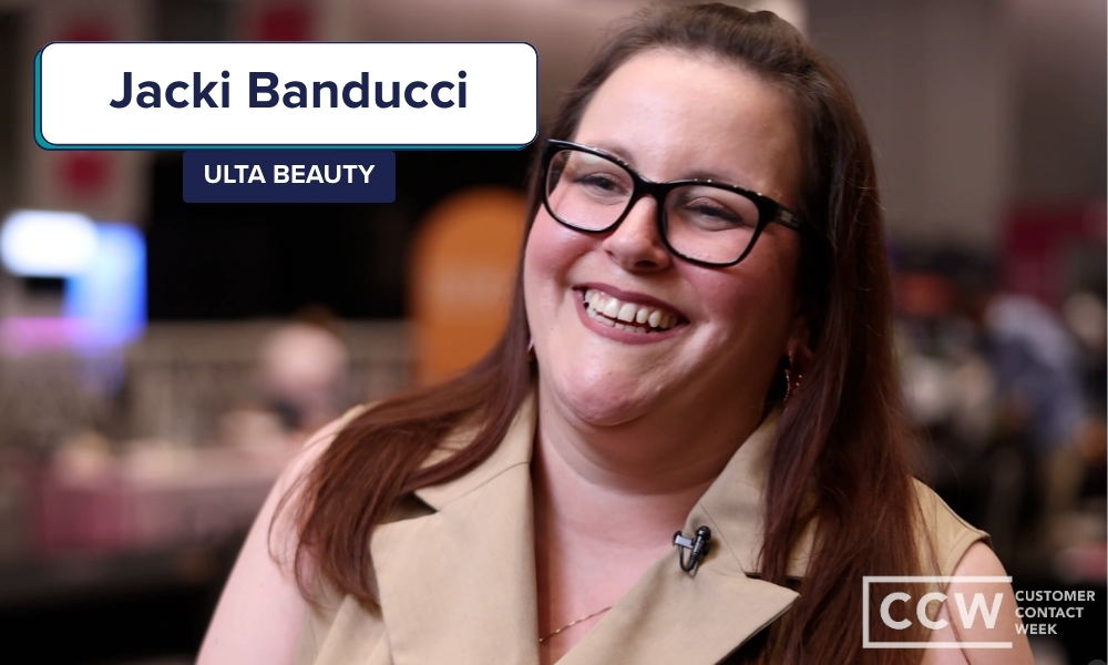 A woman wearing glasses and a beige top smiles at an event; text on screen reads "Jacki Banducci, Ulta Beauty" and "CCW Customer Contact Week.