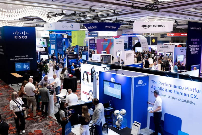 Crowded convention center with attendees visiting various technology company booths, including Cisco, Amazon Connect, and SuccessK, at a business expo.